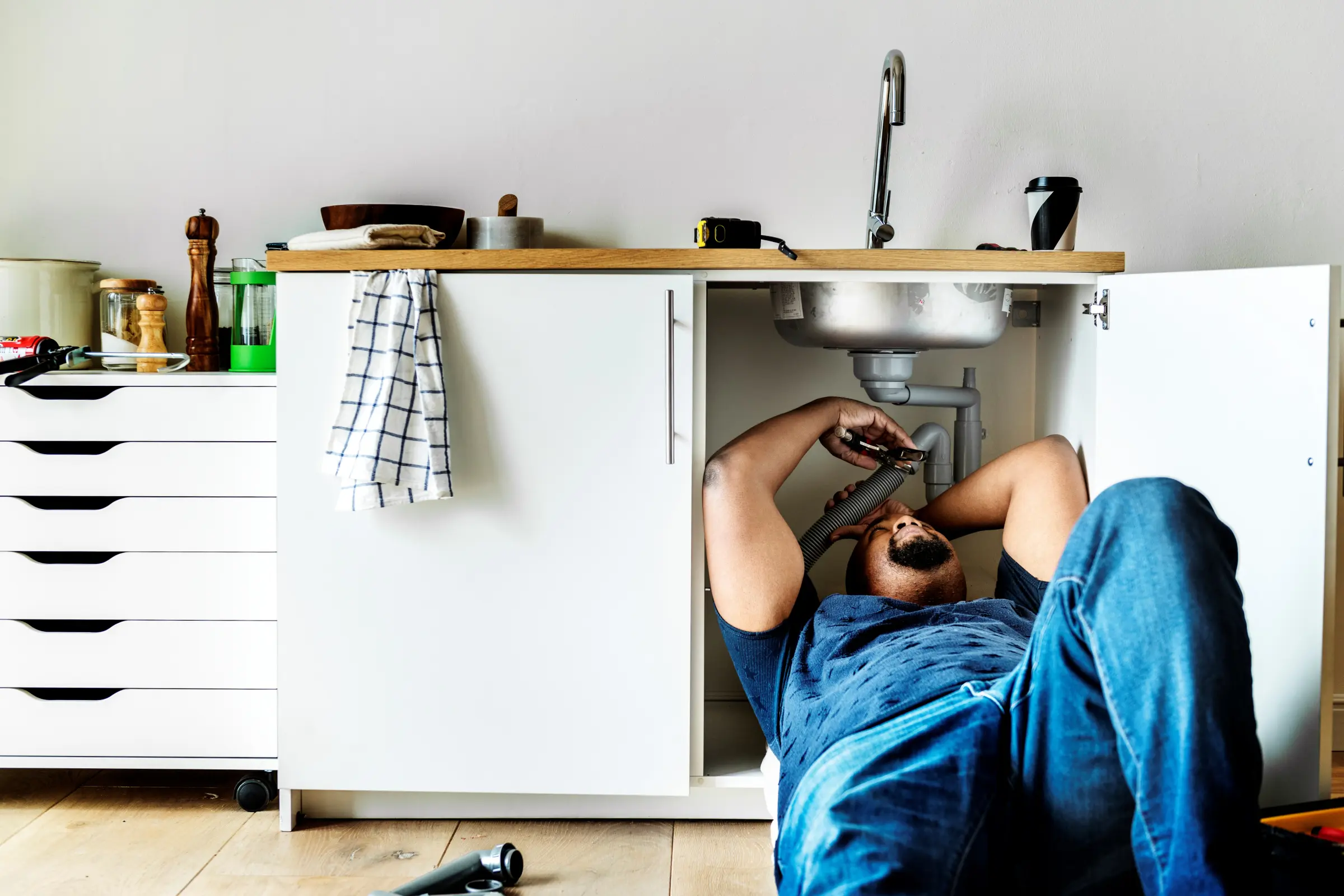 Plumber repairing a sink in a rental unit