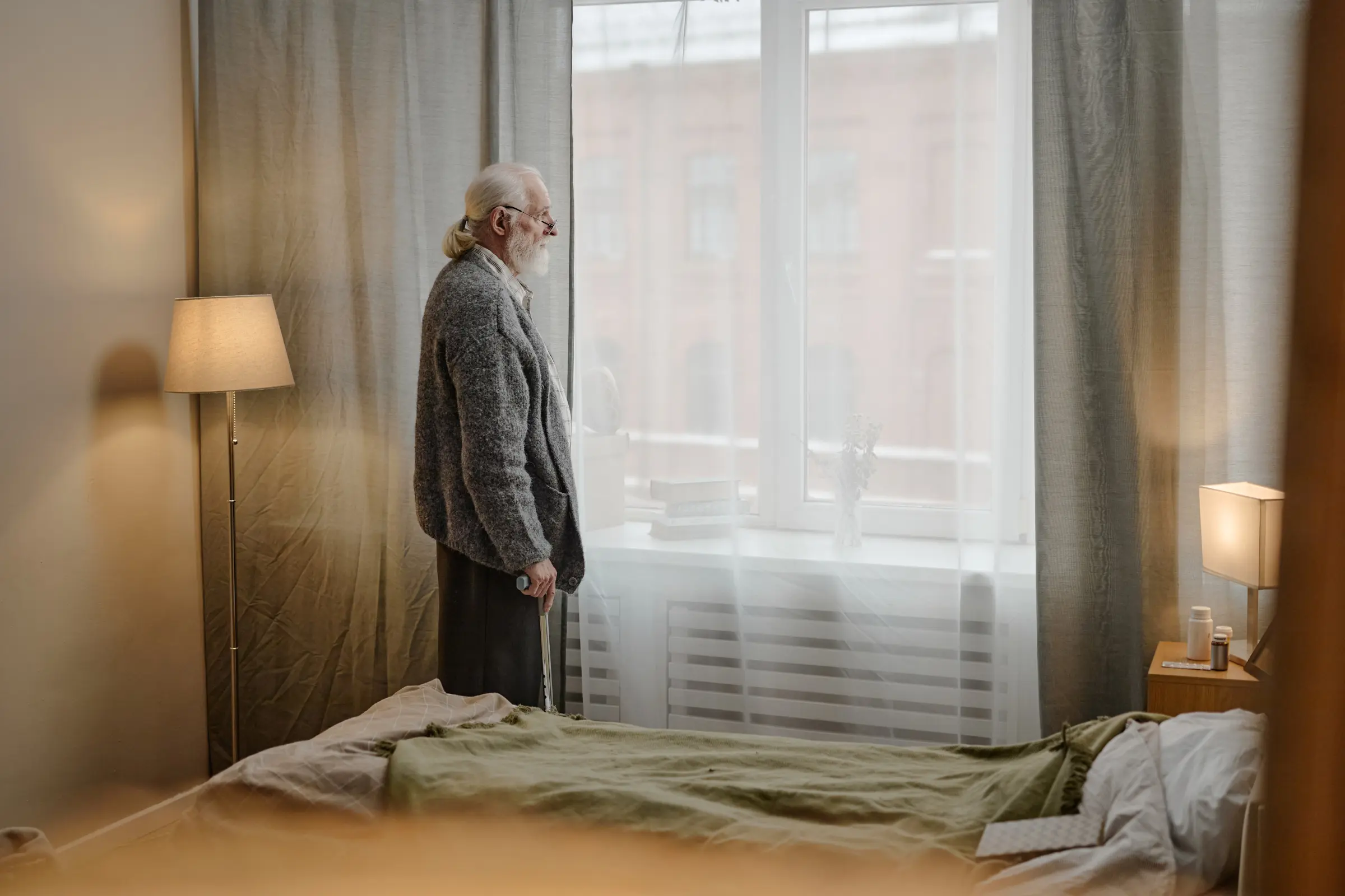 Elderly man at the window of his rental unit
