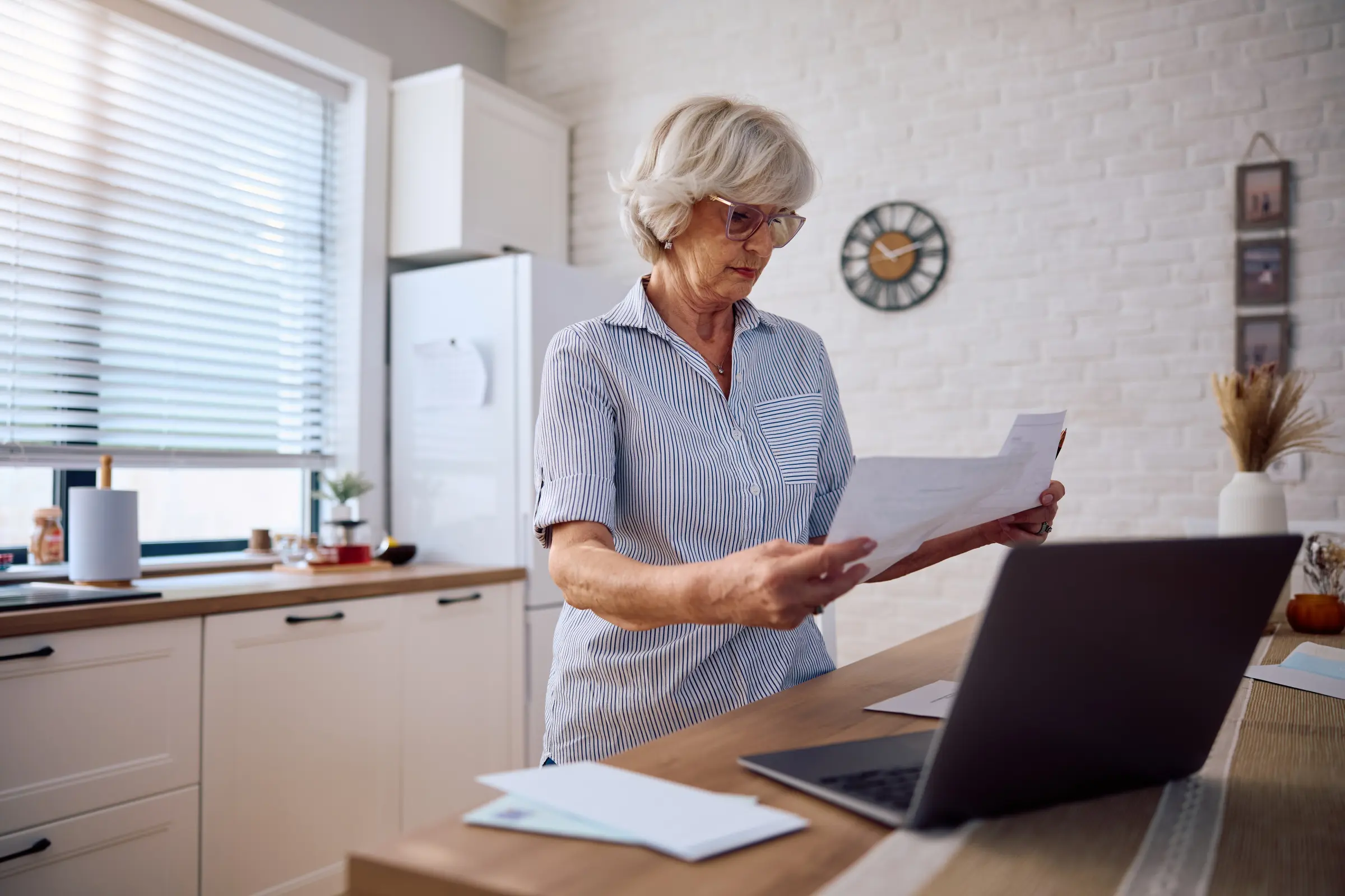senior woman consulting the documentation on the capital gains tax surcharge