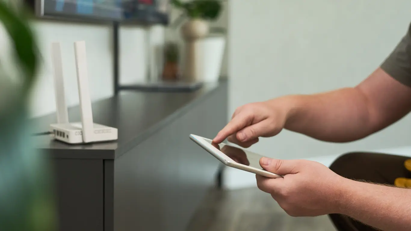 Homme réglant ses appareils connectés via sa tablette électronique
